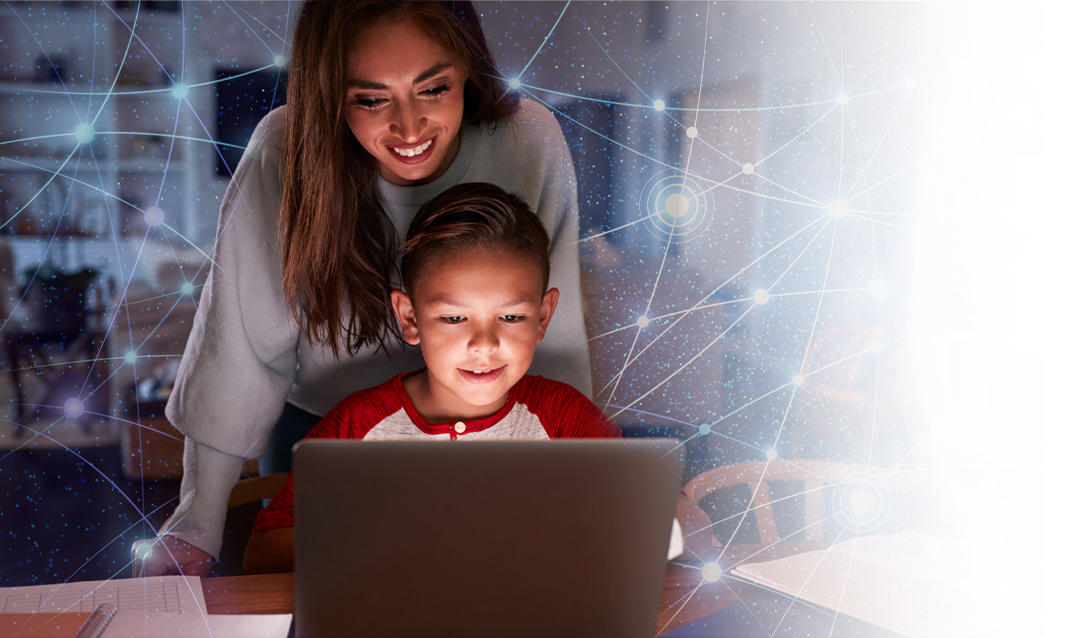 Child on laptop as mom watches over his shoulders